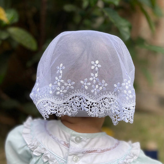 Back view focusing on the delicate embroidered lace of an infant's white chapel veil.