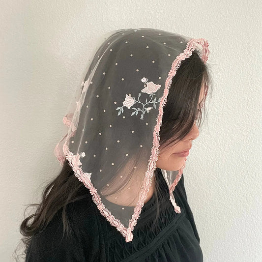 Girl in a traditional Catholic pink triangle veil with embroidered roses.