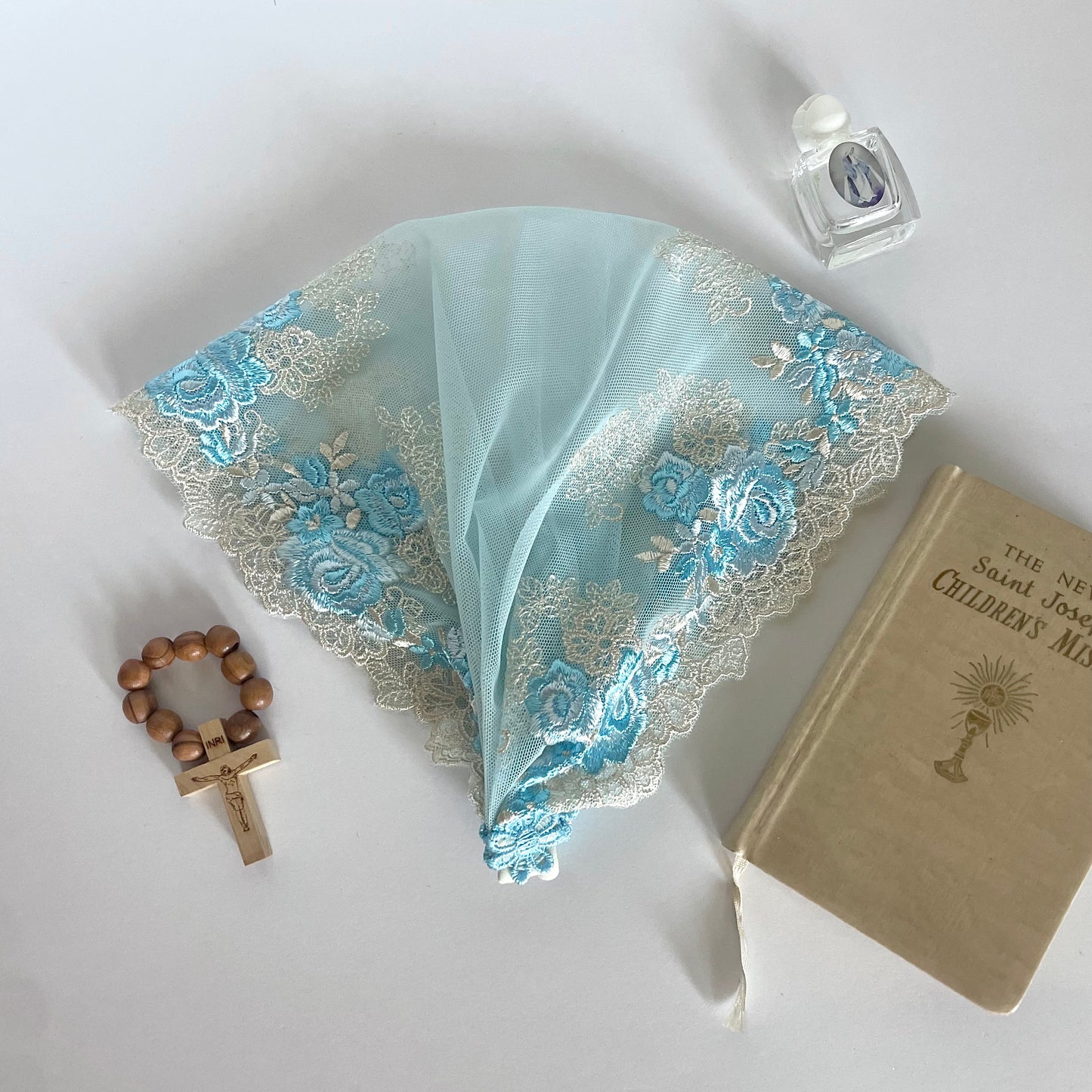 Light blue lace veil with rose embroidery. The baby or toddler mantilla is perfect for Traditional Catholic Christian Mass