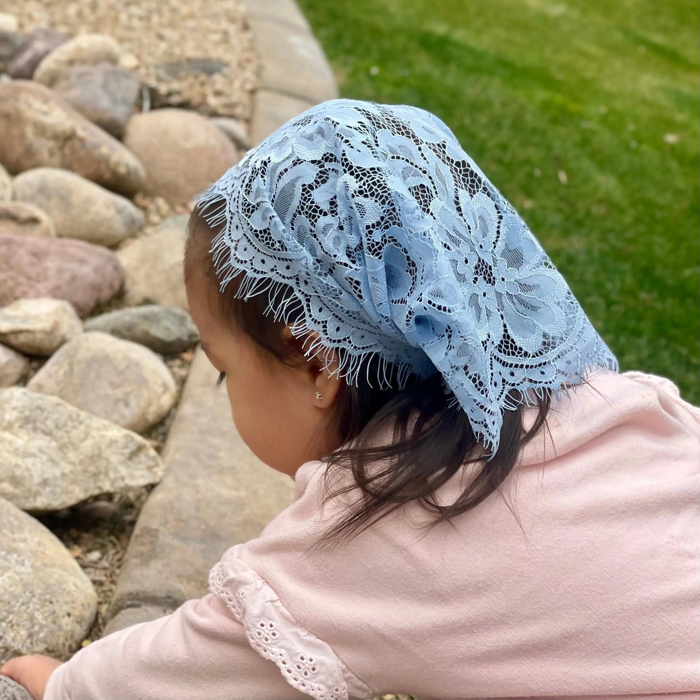 Child wearing a blue eyelash lace chapel veil.
