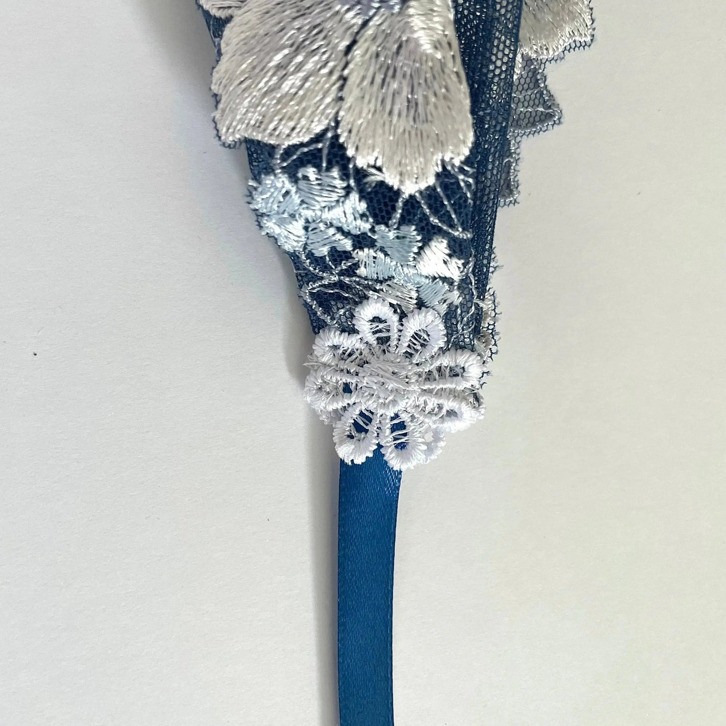 Dark blue lace chapel veil with ribbon ties and rose embroidery. The small girl veil headband also acts as a kerchief bandana