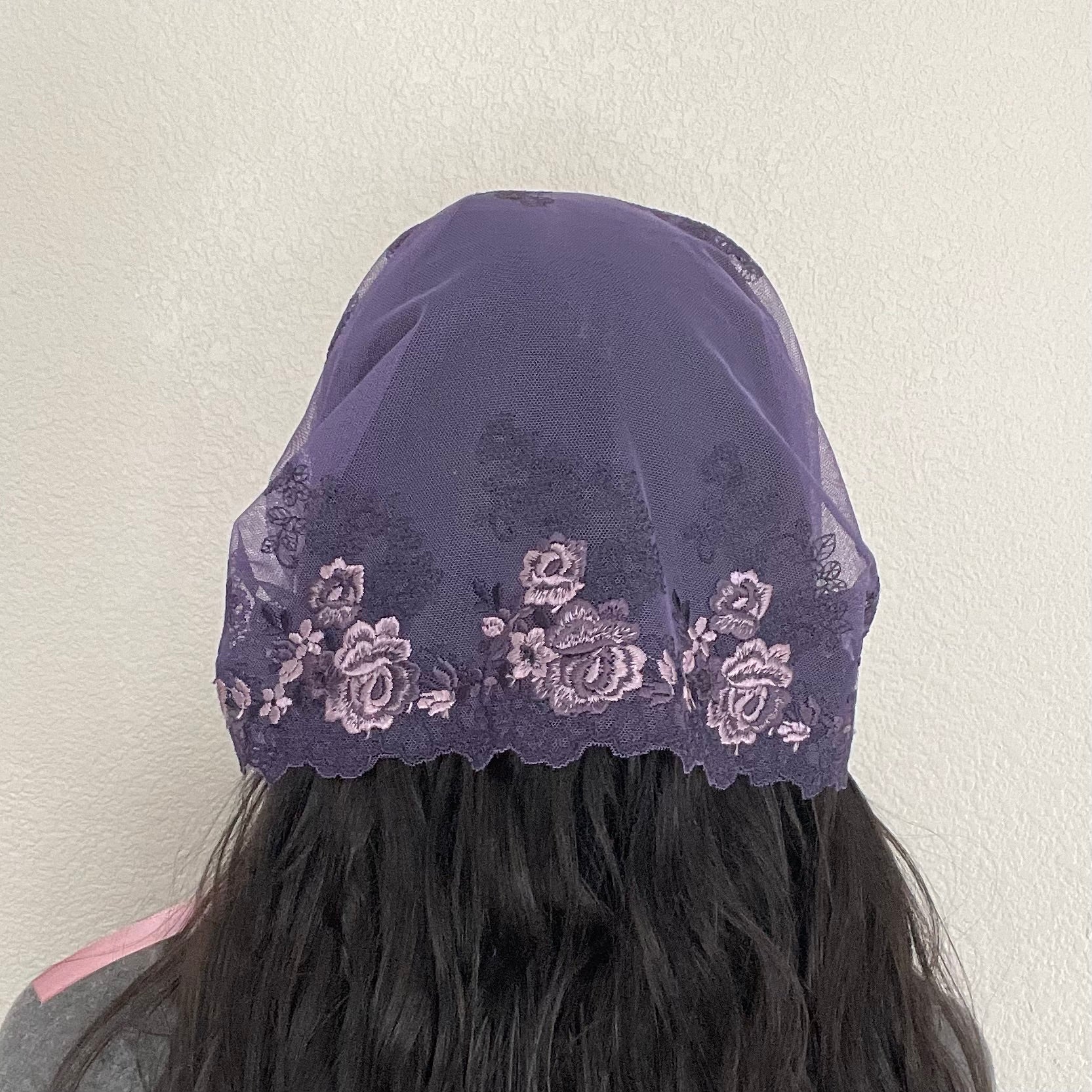 Girl wearing a lace chapel veil with rose embroidery. The Traditional Catholic Christian Mass mantilla is small