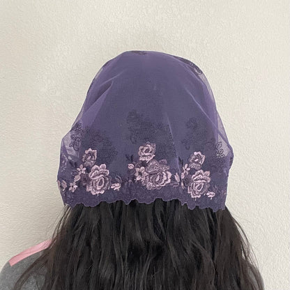 Girl wearing a lace chapel veil with rose embroidery. The Traditional Catholic Christian Mass mantilla is small