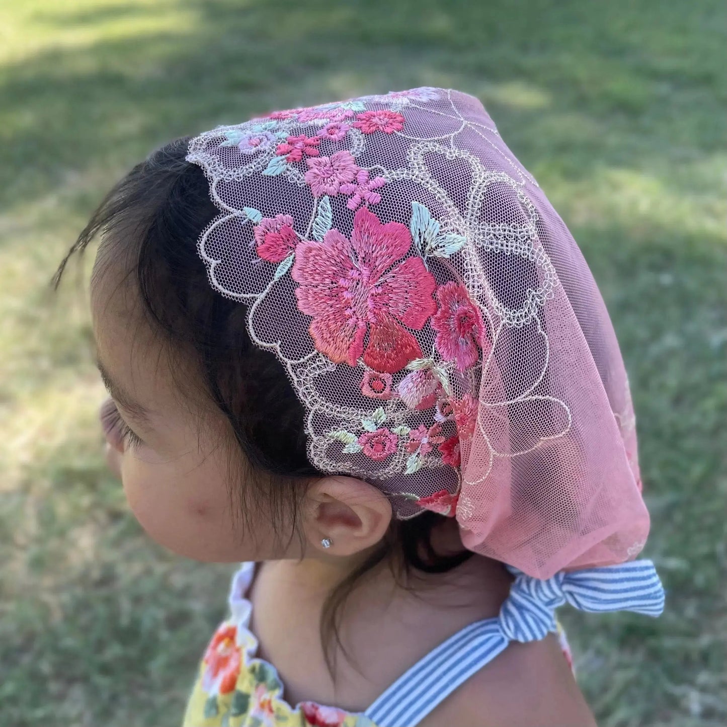Toddler's top view, highlighting the floral embroidered lace detailing on a Christian chapel veil.