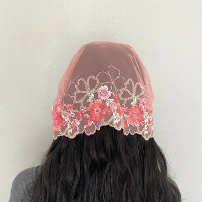 Back view of girl wearing an embroidered pink lace traditional chapel veil.