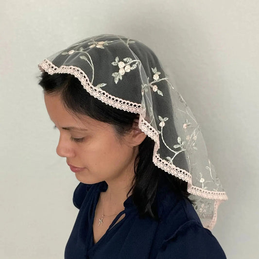 Girl wearing an embroidered pink floral lace princess veil for Traditional Catholic mass.