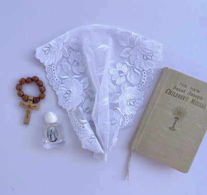 Infant ivory lace chapel veil headband for a traditional Catholic baptism ceremony.