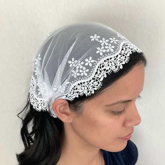 Girl wearing a one size white lace embroidered Catholic mass chapel veil.