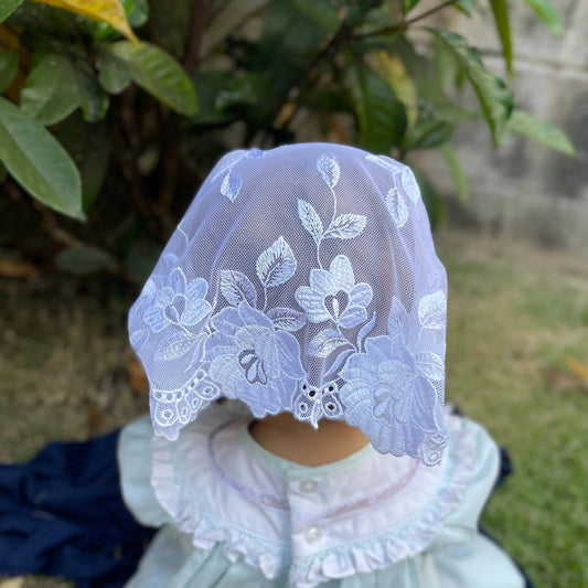 Back view of an infant wearing an ivory embroidered lace chapel veil for Traditional Catholic mass.