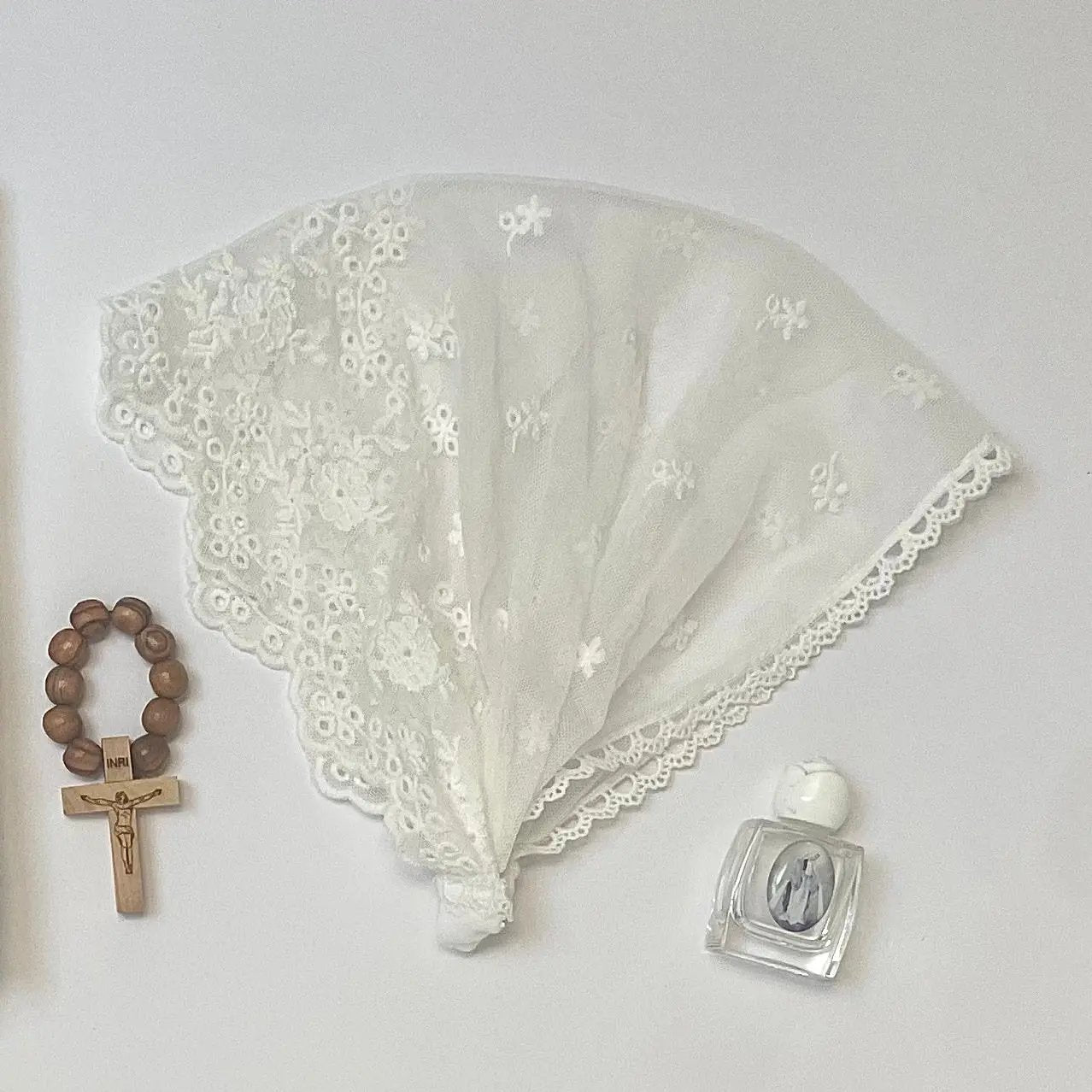 Infant white lace chapel veil headband for a traditional Catholic ceremony.
