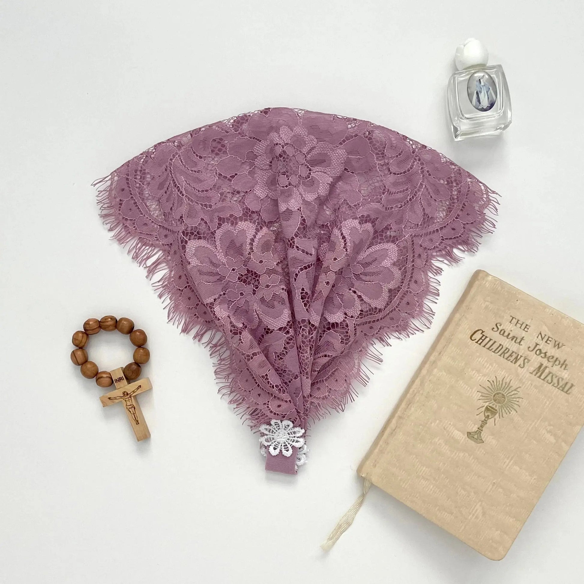 Light purple floral eyelash lace newborn veil for a traditional Catholic prayer service.