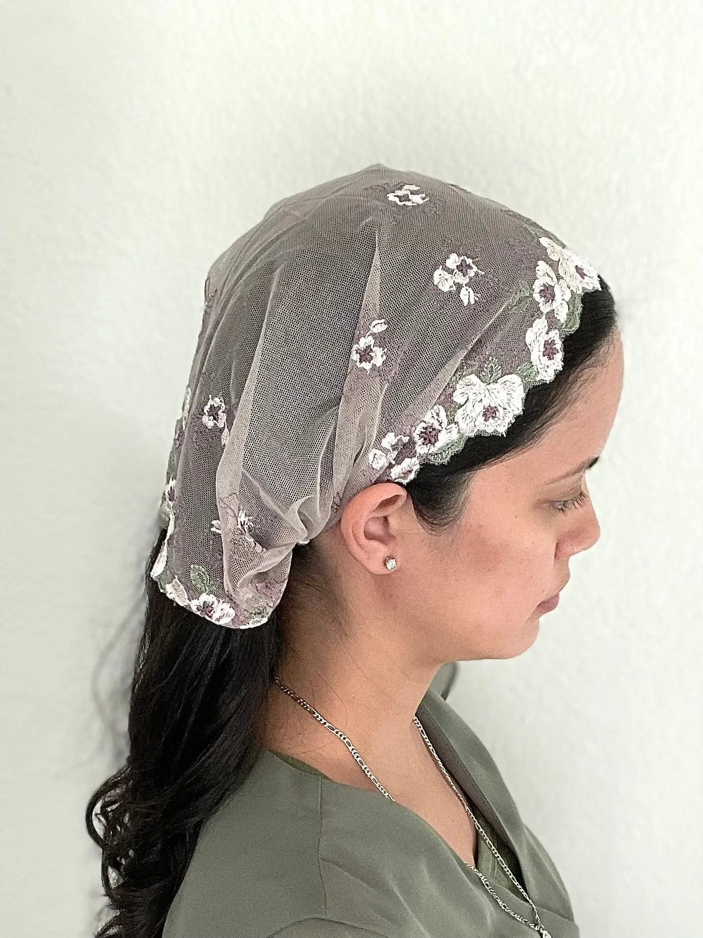 Girl wearing a light purple lace embroidered traditional Christian mass veil headscarf.