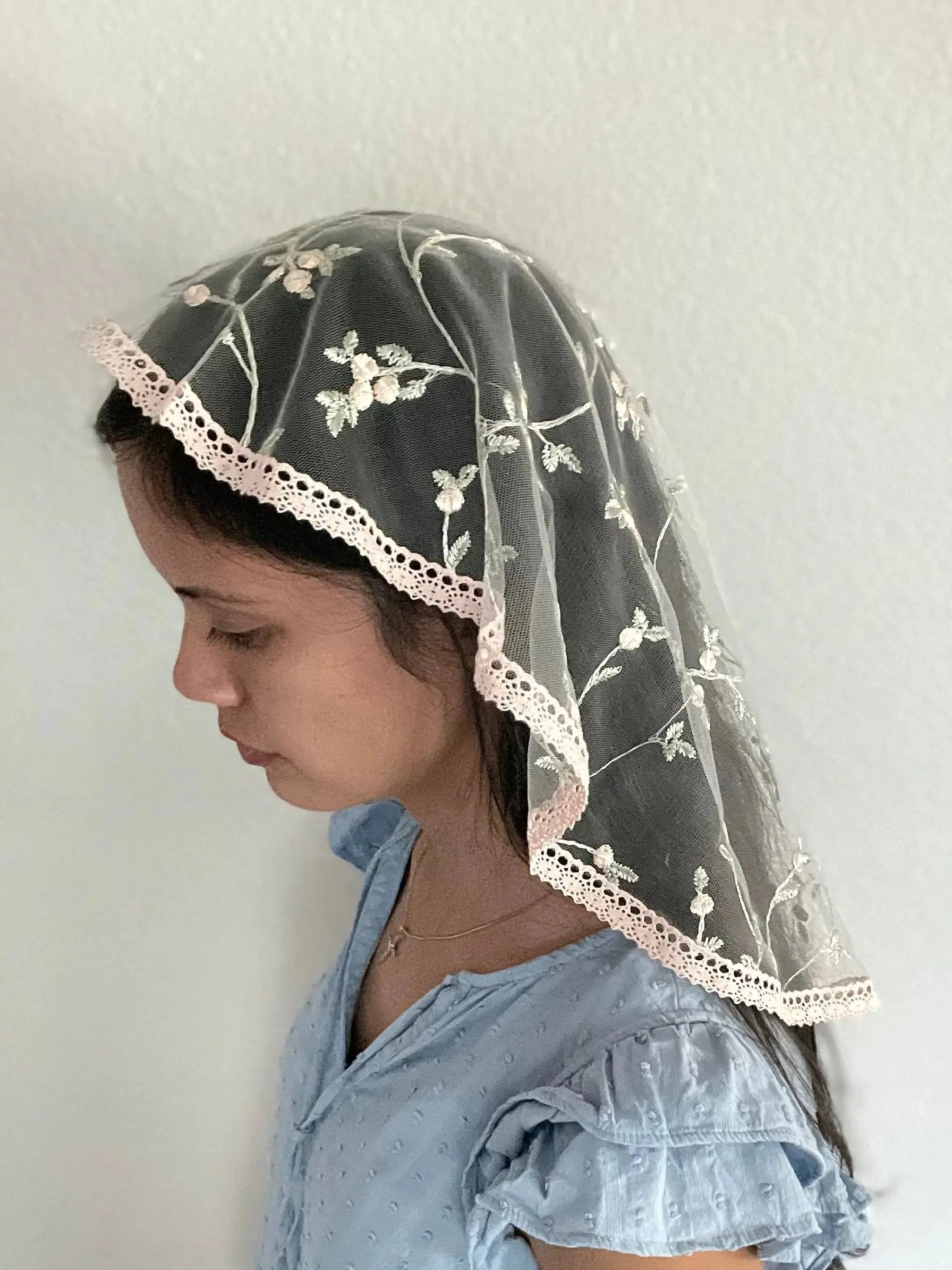 Girl wearing a floral pink embroidered lace princess Catholic Mass.