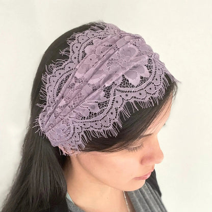 Woman wearing a small purple headscarf chapel veil in a scrunched headband style.