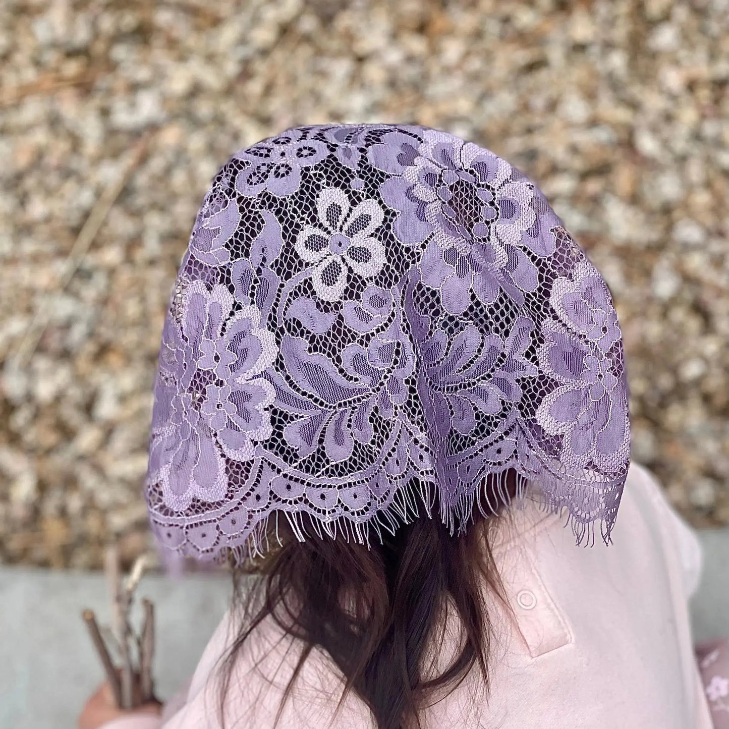 Back view of a toddler wearing a purple eyelash lace mantilla veil.