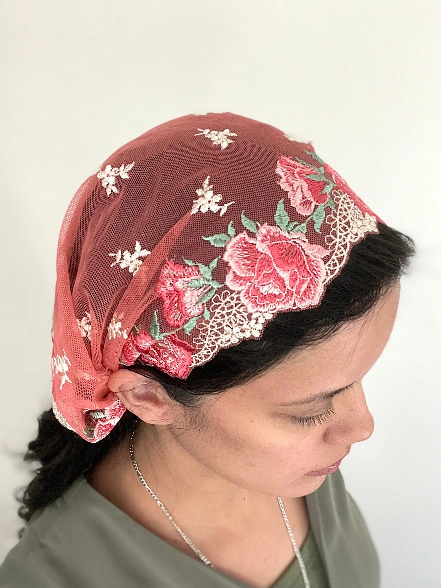 Woman wearing a beautiful red and pink embroidered lace chapel veil kerchief.