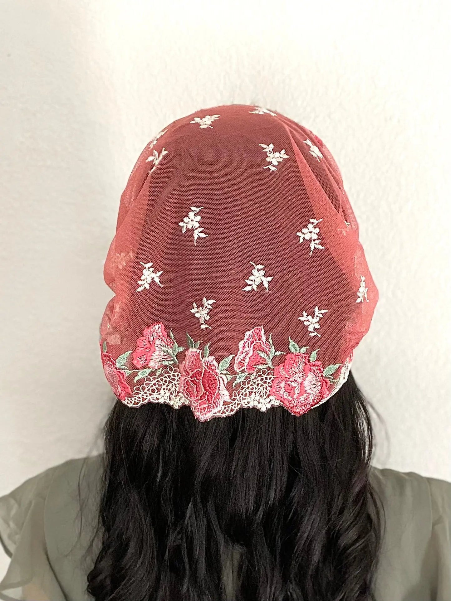 Back view of girl wearing a beautiful red and pink embroidered lace chapel veil kerchief.