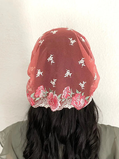 Back view of girl wearing a beautiful red and pink embroidered lace chapel veil kerchief.