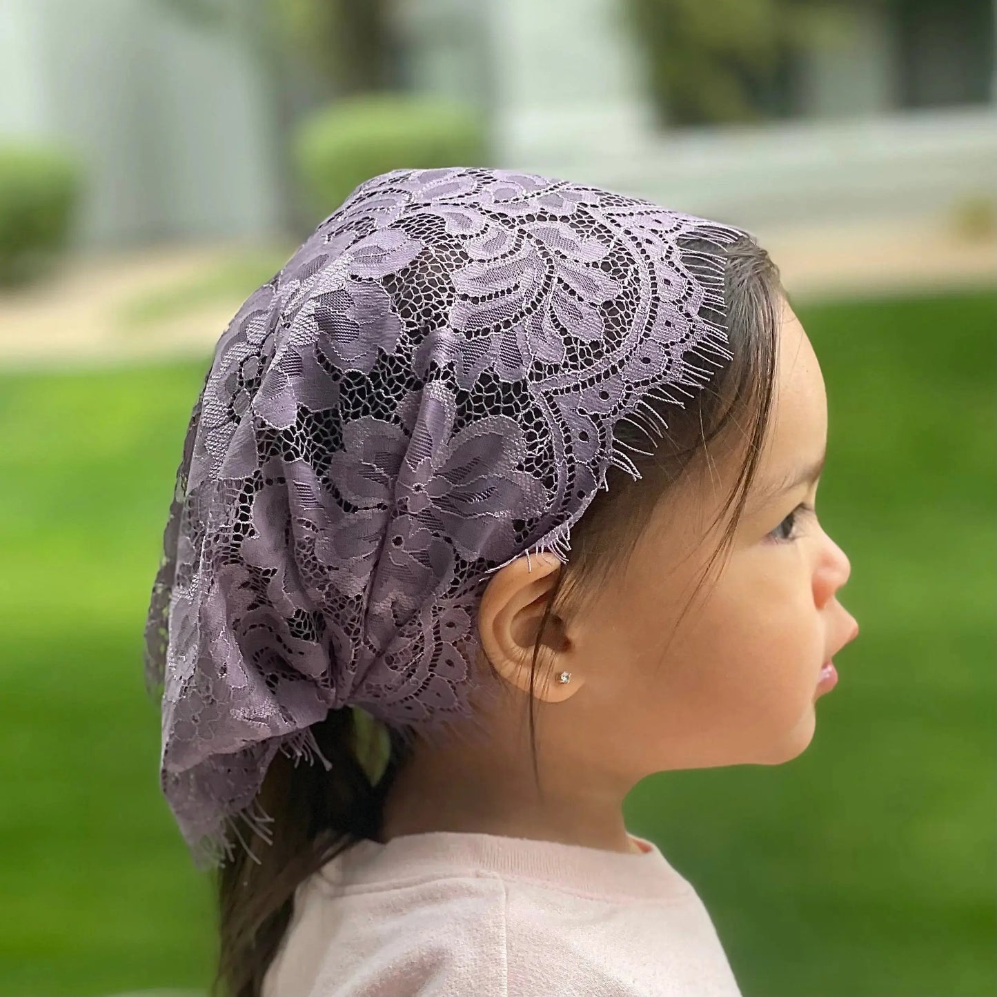 Toddler wearing a dark purple eyelash lace mantilla for traditional Catholic devotions.