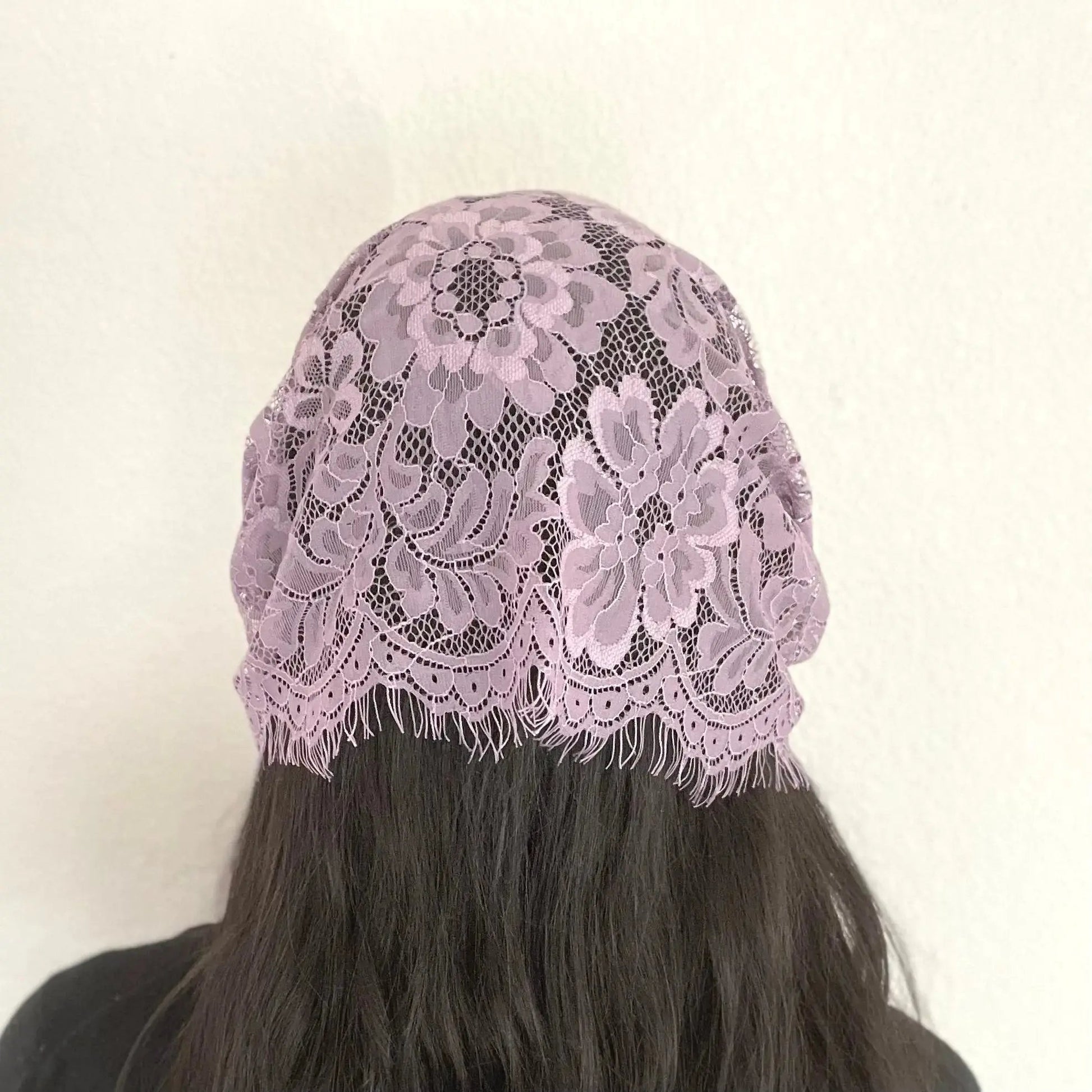 Back view of girl wearing a traditional purple eyelash lace Catholic chapel veil for the season of Lent.