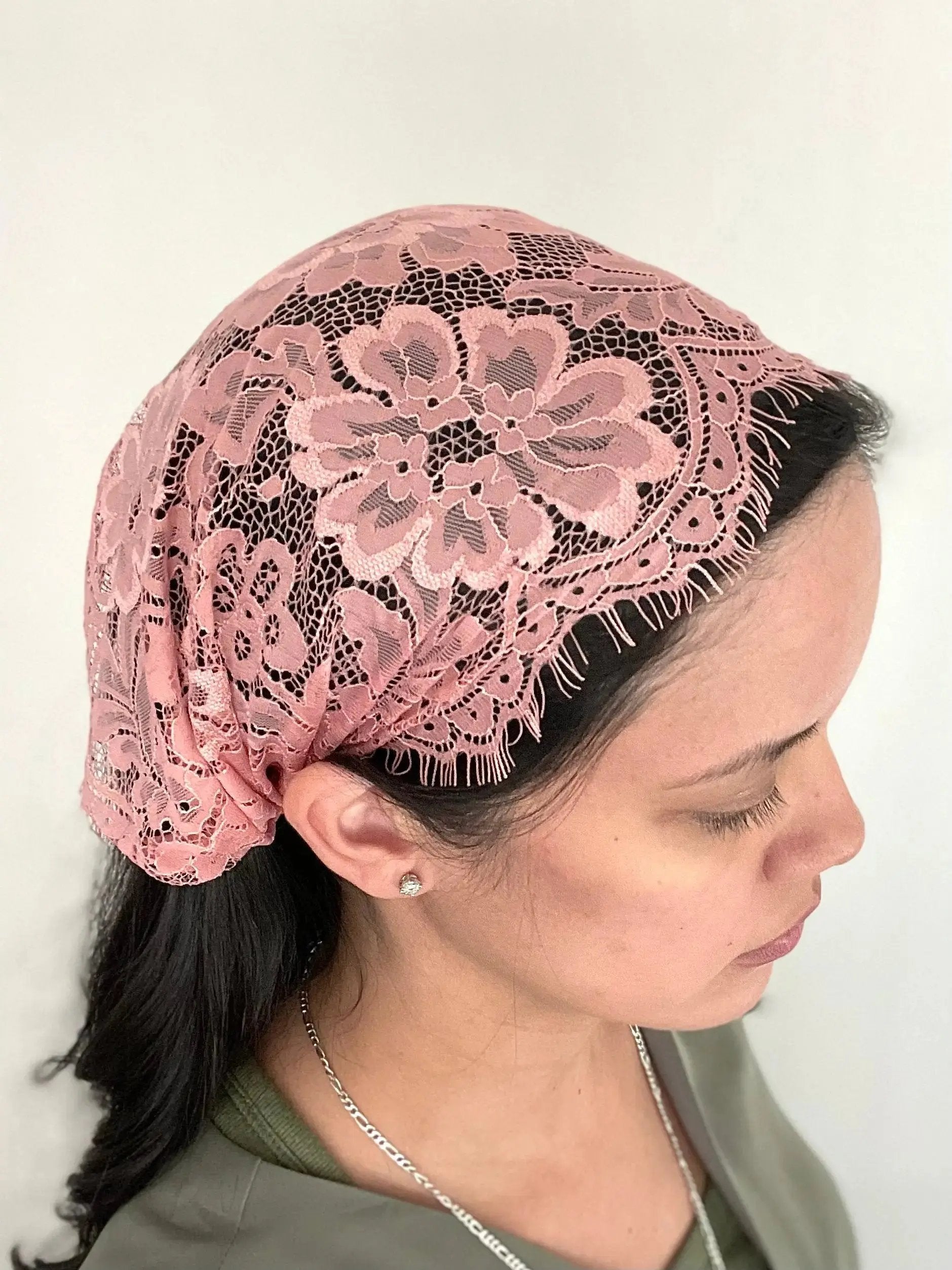 Woman wearing a dark pink eyelash lace Traditional Catholic chapel veil headscarf bandana.