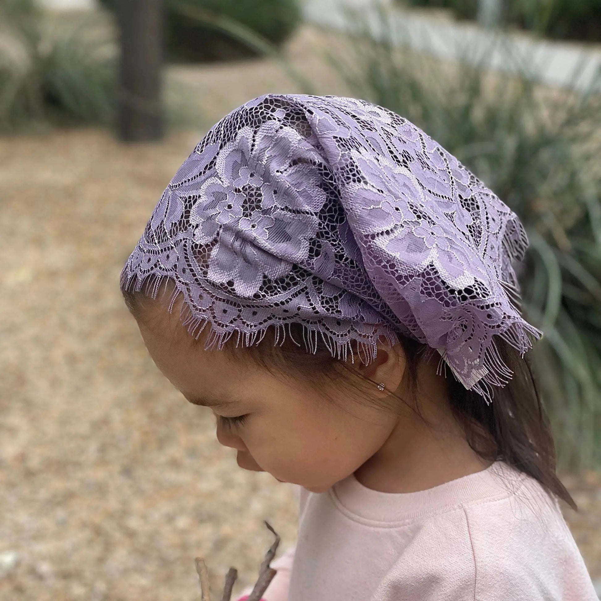 Baby wearing a simple purple chapel veil for traditional Christian services.
