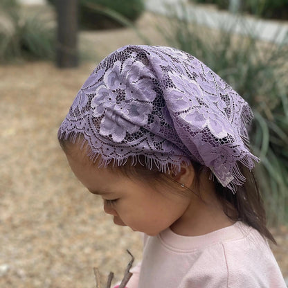 Baby wearing a simple purple chapel veil for traditional Christian services.